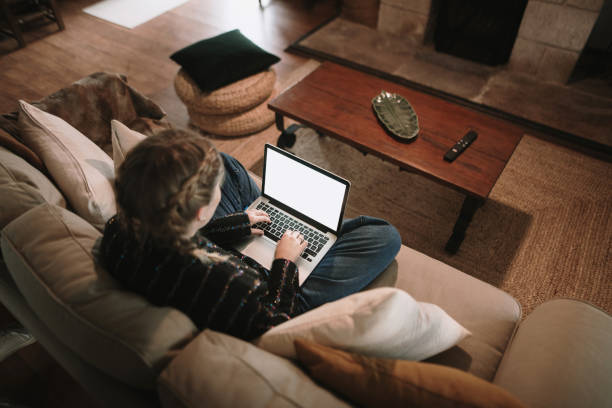 istock Young woman using laptop sitting in a sofa 1280325212