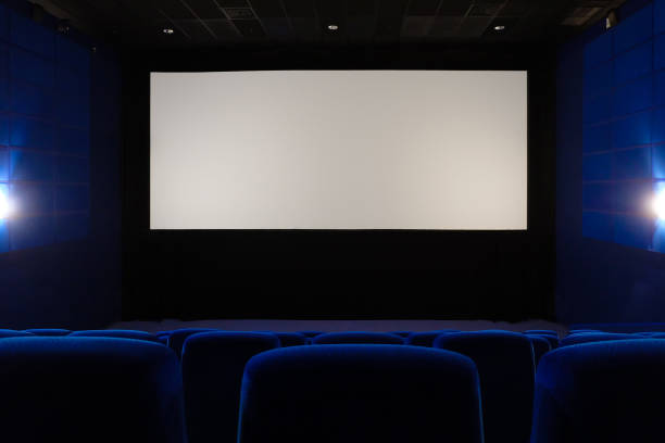 Empty cinema hall. View of empty white cinema screen from the upper rows of the auditorium. stock photo