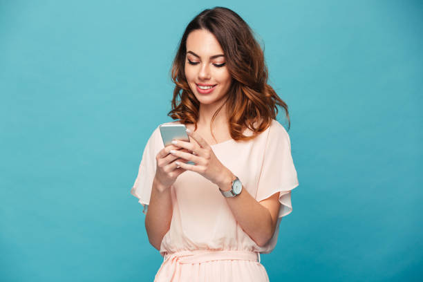 istock Contented smiling woman typing text message or scrolling through social networks using smartphone, isolated over blue background 1280325572