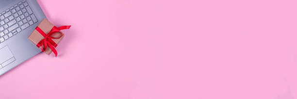 istock Banner with top view on laptop computer, present box with red bow on pastel pink background with copyspace for your text. Seasonal sale, black friday and cyber monday concept. Online shopping 1280325807