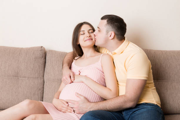 Happy pregnant woman and her husband waiting for baby at the home. happy family love and care concept Happy pregnant woman and her husband waiting for baby at the home. happy family love and care concept. couple hope sky blue stock pictures, royalty-free photos & images