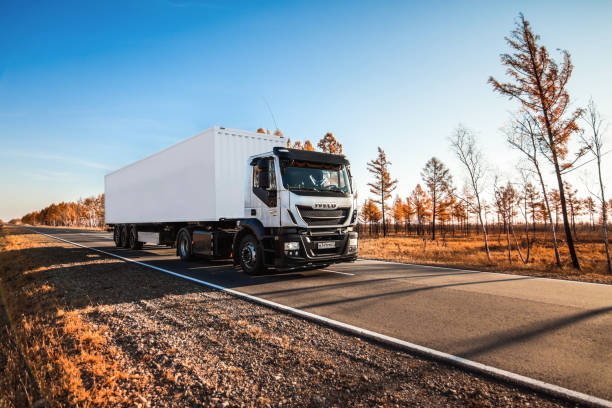IVECO truck with white trailer on the road in autumn Khabarovsk, Russia - October 13, 2018: IVECO truck with white trailer on the road in autumn volvo stock pictures, royalty-free photos & images