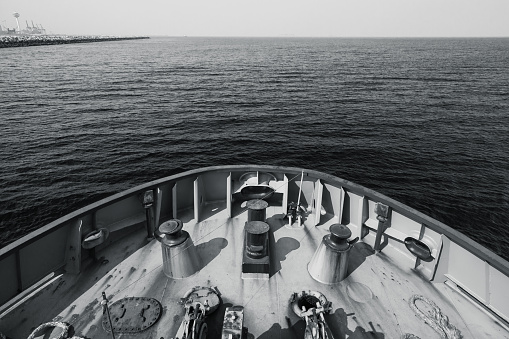 Bow of a tug boat and seawater. Blue toned monochrome photo taken from a captains bridge