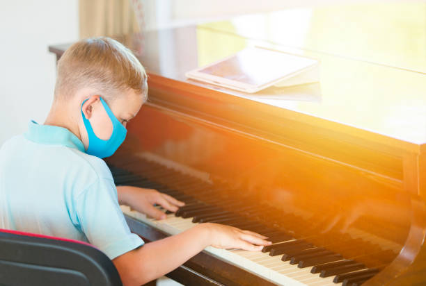 istock Rear View Of Boy Playing Piano 1280328635