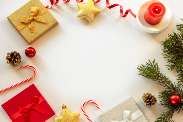 istock Festive Christmas background with gift boxes, fir tree, candle, candy cane and baubles. Top view, copy space 1280329545