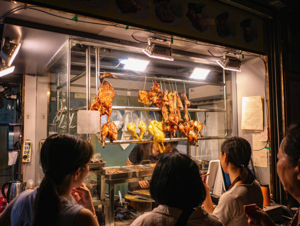 広州市の繁華街の路地でローストグースボイルドチキンを購入する知り合いの人々。広東省の首都広州または広州は、中国で3番目に大きな都市です。 - store market china city street ストックフォトと画像