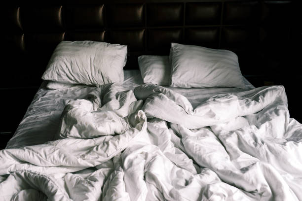 istock Unmade double empty bed with white linens. Sheets and pillows in the apartment or hotel after a night's sleep. The bed was dirty and unmade. Rumpled blanket in the bedroom 1280331732