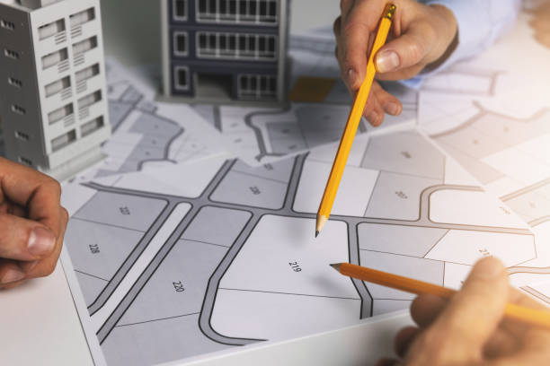 urban planning - people discussing about territory building plots on cadastral map for apartment building construction