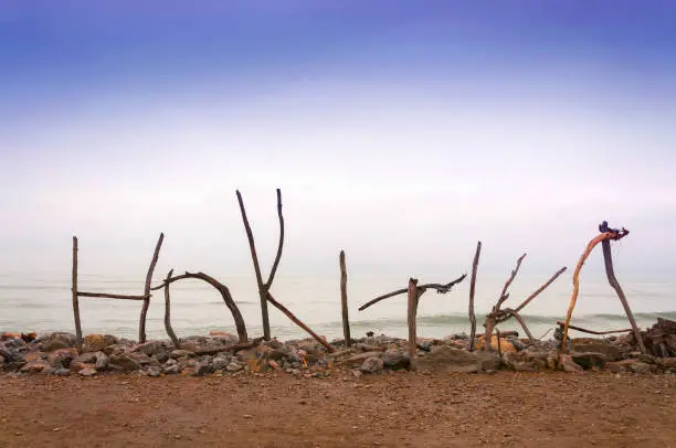 Hokitika beach sign, made of sticks and tree branches