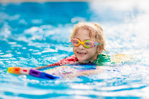 istock Child learning to swim. Kids in swimming pool. 1280336211