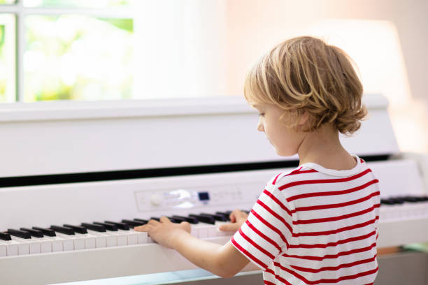 istock Child playing piano. Kids play music. 1280337283