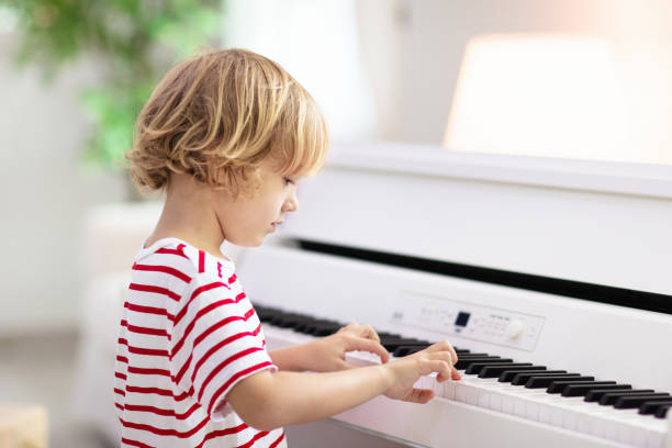 istock Child playing piano. Kids play music. 1280337423