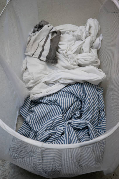 istock Dirty bedding inside fabric mesh laundry basket top view 1280340755