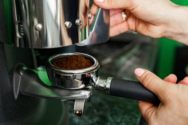 istock Woman coffee shop worker preparing coffee on professional coffee machine 1280342103