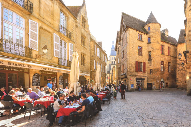 People having lunch on restaurant terrace in Sarlat, France Sarlat - France, 21 October 2018: Tourists having lunch on restaurant terrace in Sarlat lovely town located at southwest France's Dordogne department sarlat la caneda stock pictures, royalty-free photos & images