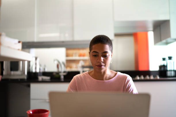 istock Focused woman using laptop at home 1280345446