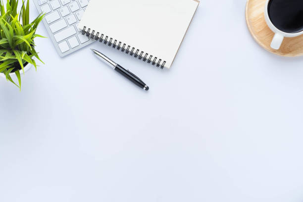 istock Top view above of White office desk table with keyboard, notebook and coffee cup with equipment other office supplies. Business and finance concept. Workplace, Flat lay with blank copy space. 1280347453