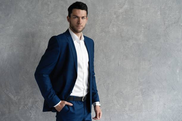 istock Handsome man wear blue suit isolated on grey background. 1280348135