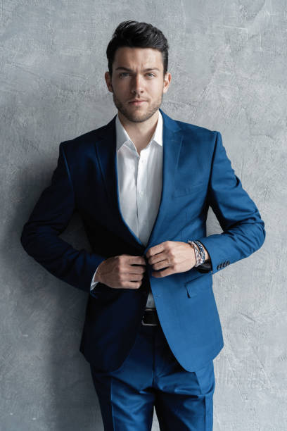 istock Handsome man wear blue suit isolated on grey background. 1280348187
