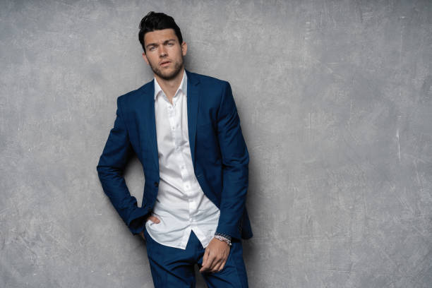 Handsome man wear blue suit isolated on grey background.