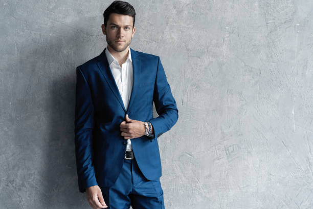 istock Handsome man wear blue suit isolated on grey background. 1280348197