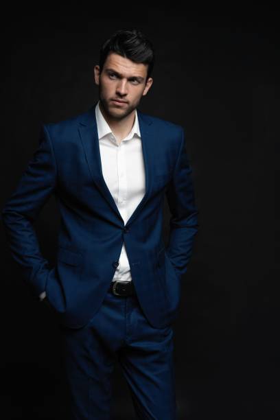 istock Handsome man wear blue suit isolated on black background. 1280348232