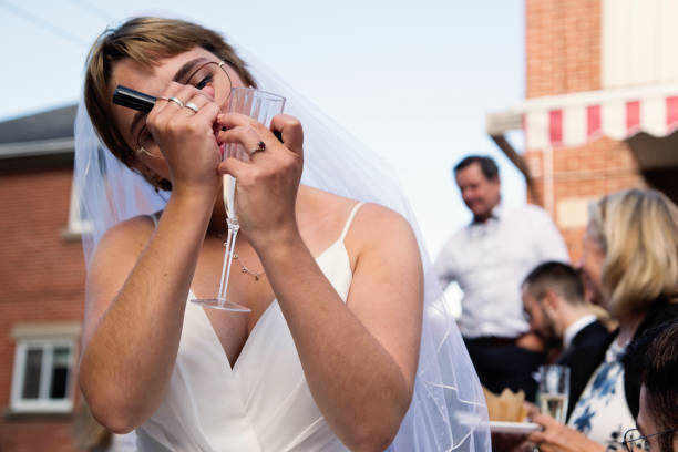 istock Millennial bride writing name on glass at wedding cocktail in backyard. 1280348241
