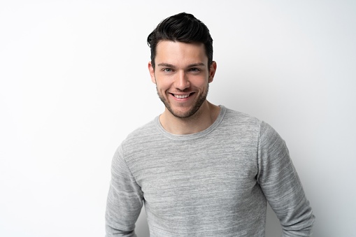 Handsome young man on white background looking at camera. Happy guy smiling.