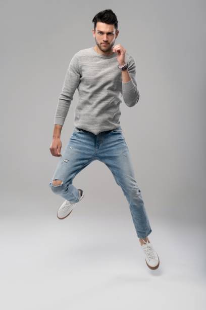 istock Handsome young man running or jumping in air on white background. 1280348487