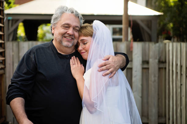 istock Millennial bride posing with father at wedding cocktail in backyard. 1280348500
