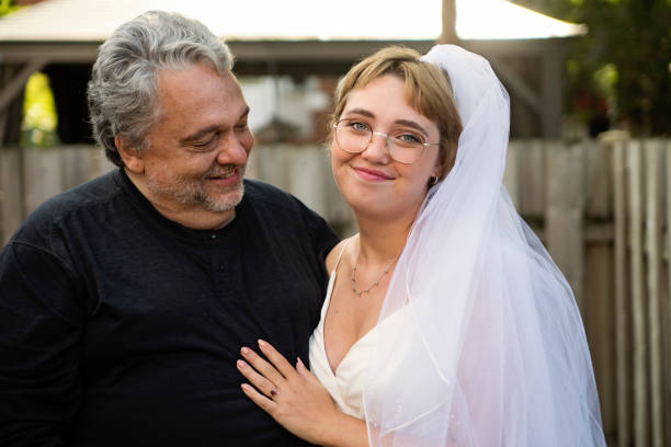 istock Millennial bride posing with father at wedding cocktail in backyard. 1280348761