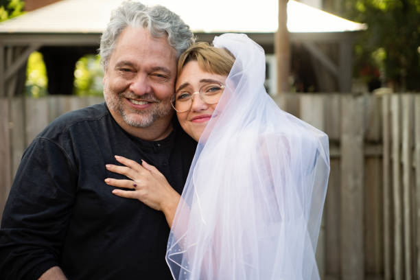 istock Millennial bride posing with father at wedding cocktail in backyard. 1280348823
