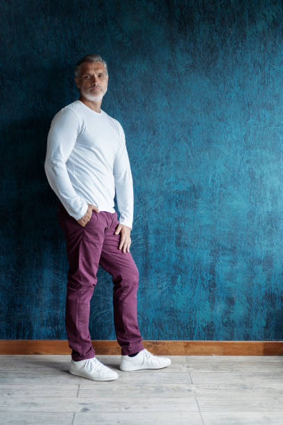 istock Casual Grey-haired Mature handsome man portrait over dark blue wall background. 1280349130