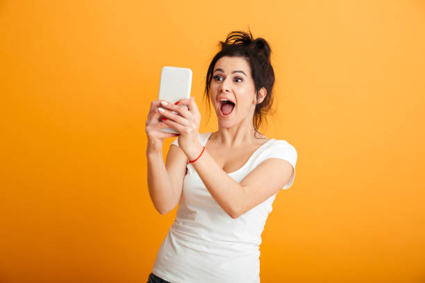 istock Shocked young woman using mobile phone. 1280350339