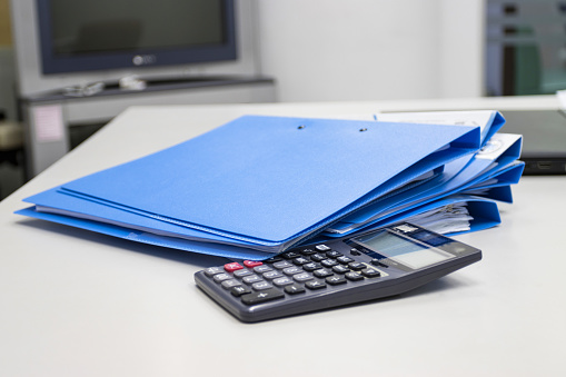 file folder with documents and  Calculator on table in meeting room