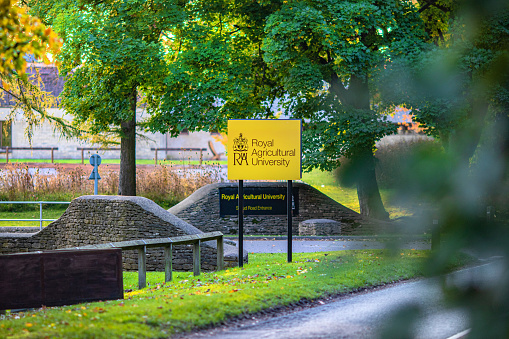 Entrance signs outside the The Royal Agricultural University on the A419 Between Cirencester and Stroud. The RAU is a university in Cirencester, Gloucestershire, The Cotswolds, England and was established in 1845.