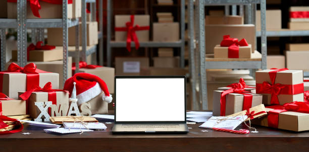 倉庫の背景にプレゼントギフトボックスとメリークリスマステーブル上の白い空白の空のモックアップ画面を持つラップトップコンピュータ。eコマースウェブサイトxmasオンラインショッピ� - box white blank computer software ストックフォトと画像