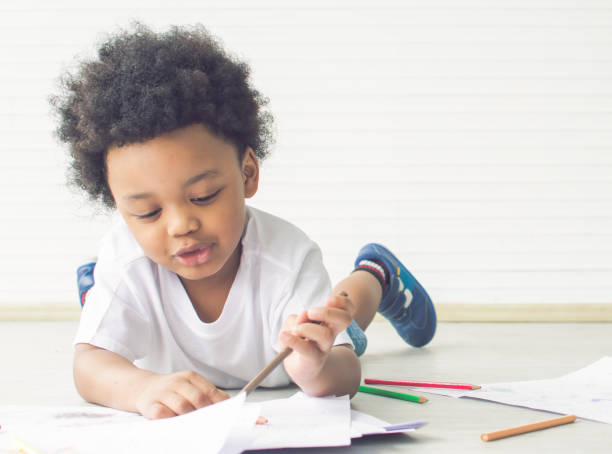 istock Little african boy is drawing and painting 1280359467