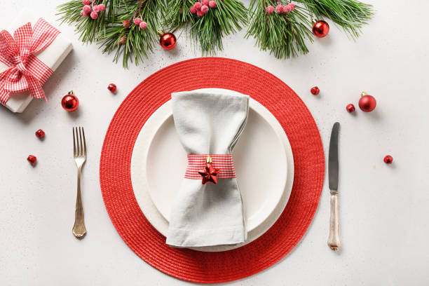 istock Christmas table setting with white and red holiday decorations on white table. Top view. 1280360345