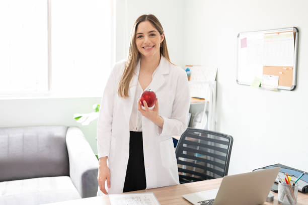 istock Female nutritionist holding an apple 1280362559