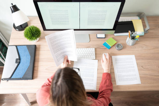 Female translator working on a document Top view of the workspace and office of a female translator working on a document and checking some references content stock pictures, royalty-free photos & images