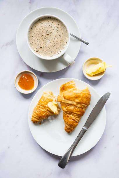 un croissant francese appena sfornato, caffè, burro e marmellata - preserves croissant breakfast food foto e immagini stock