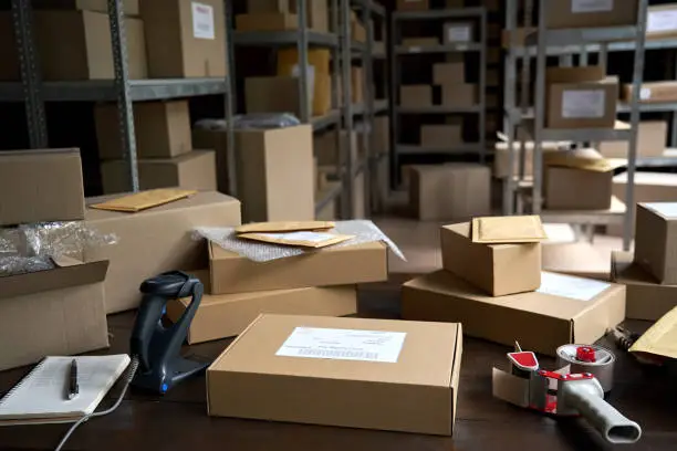 Photo of Distribution warehouse background, commercial shipping order boxes for dispatching on stockroom table, post courier delivery package, dropshipping commerce retail store shipment storage concept.