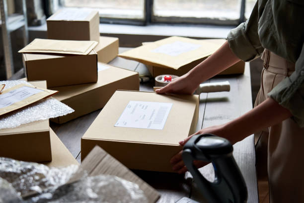 istock Female distribution warehouse worker or seller packing ecommerce shipping order box for dispatching, preparing post courier delivery package, dropshipping commerce retail shipment service concept. 1280366083