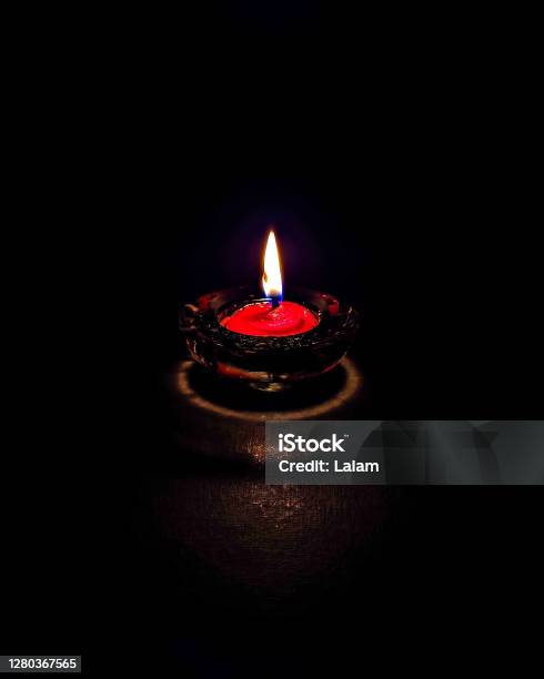 Isolatedclose Up Image Of Small Red Colored Wax Lamp Burning In Dark Night With Steady Yellowblue Flame Stock Photo - Download Image Now