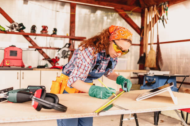 istock Young female carpenter measures the board with a ruler and using tablet. 1280368646