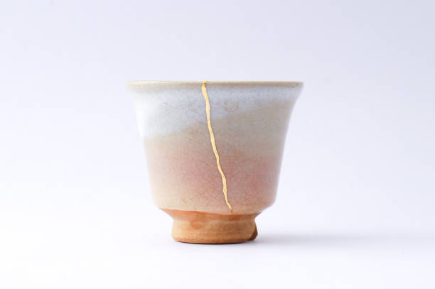 Antique broken Japanese beige sake cup repaired with gold kintsugi technique