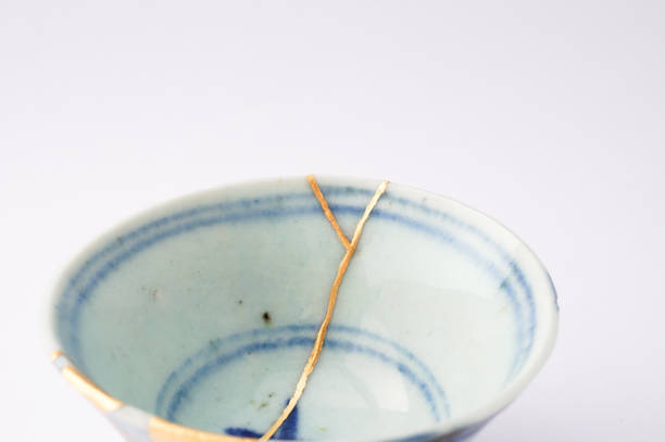 Kintsugi bowl Antique broken Japanese pottery repaired with gold. stock photo