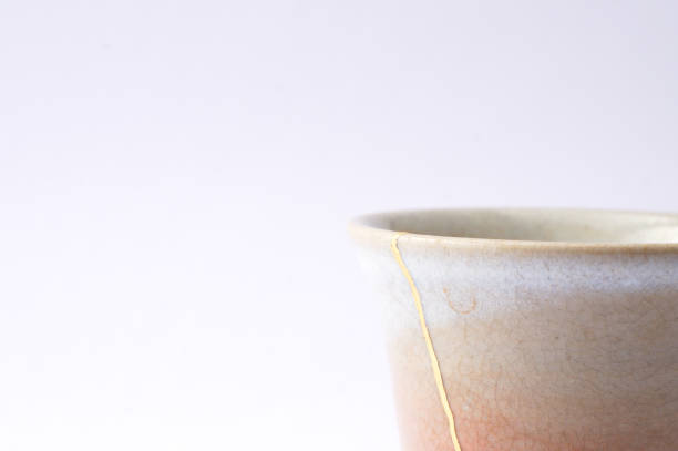 istock Antique broken Japanese beige sake cup repaired with gold kintsugi technique 1280370379