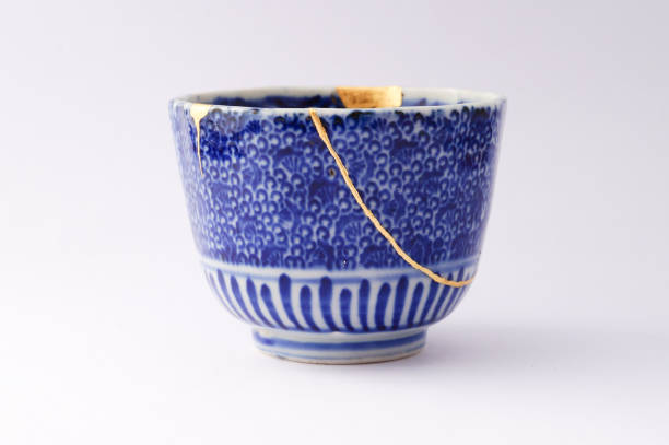 Kintsugi Antique broken Japanese cup repaired with gold. stock photo